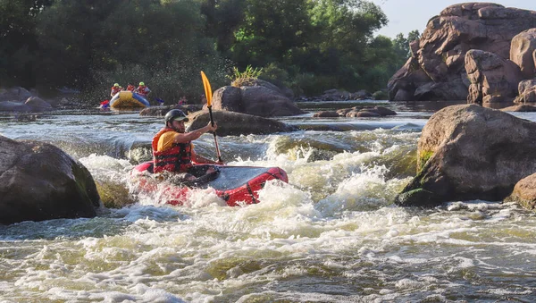 Dağ nehrinin beyaz sularında kürek çeken bir adam. Konsept: ekstrem su sporları, aktif dinlenme, rafting.