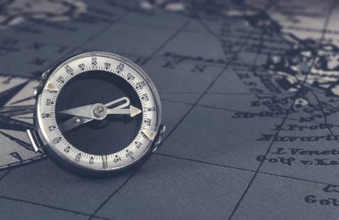 Dünya klasik haritasında manyetik eski pusula. Seyahat, coğrafya, navigasyon, turizm ve keşif konsepti. Makro çekim, sığ odak.