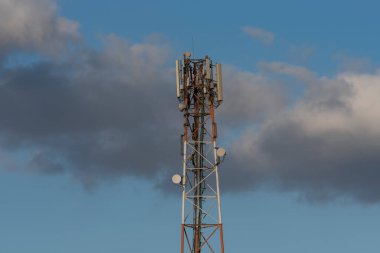 Telekomünikasyon kulesi 4G ve 5G hücresel. Makro Üs İstasyonu. Radyo modülleri ve akıllı antenleri olan 5G radyo ağı telekomünikasyon ekipmanı Coulds gökyüzü arka planında bir metal üzerine monte edilmiştir..