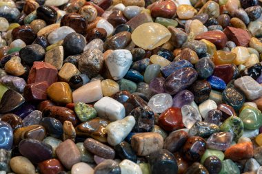 Colorful Pebble stones, rocks wet on river beach. Different nature smooth Pebble stones (green, orange, grey, red) as natural rock abstract pattern texture background.