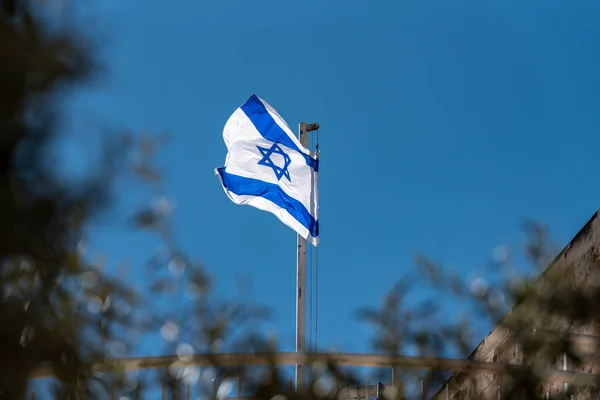 Large Israel flag waving in the wind. waving flag of israel white and blue