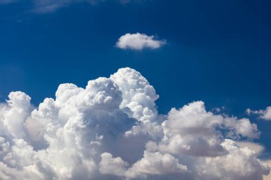 Closeup of Billowy cumulus clouds. Wispy clouds, deep blue sky in background. 