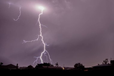 Phoenix üzerinde Arizona 'da şimşek çaktı. Renkli bulutlar; ana cıvatanın yeryüzüne çarptığı bulutlarda parlak nokta, yakınlardaki bulutlardan aşağıya doğru uzanan küçük boşluklar.