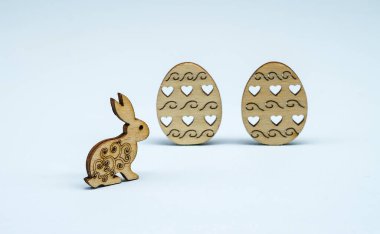 Hafif bir arka planda Paskalya dekoru. Kutsal Paskalya bayramı için dekorasyon. Yumurtalardan ahşap heykelcikler ve Paskalya için bir tavşan..