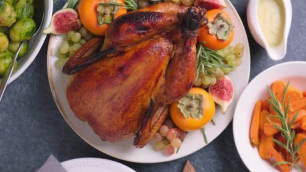 Pirított egész csirke tálalva gyümölcsökkel tálalva sötét alapon. Karácsonyi vagy hálaadási étel koncepció. — Stock videók