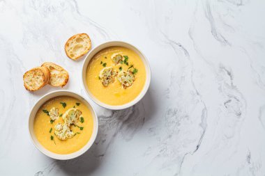 Vejetaryen krem peynir çorbası, karnabahar ve beyaz kâse, üst manzara, fotokopi alanı. Sağlıklı vejetaryen gıda kavramı.