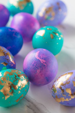 Paskalya yumurtaları mor ve mavi, beyaz mermer kaplamalı altın sarısı, yakın plan..