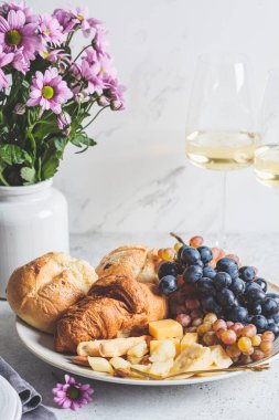 Sevgililer Günü randevusu. Meyveli peynir, çiçekli beyaz şarap bardaklı çörekler..