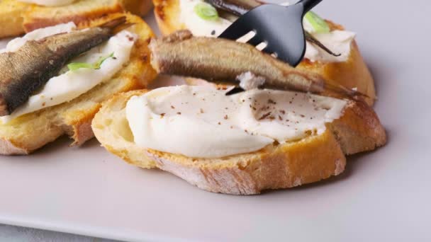 Hands cooking toast with cream cheese, sprats or sardine and green onions. — Stock Video