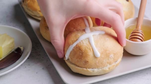 Manos cocinando pan cruzado de Pascua con pasas y mantequilla. — Vídeo de stock