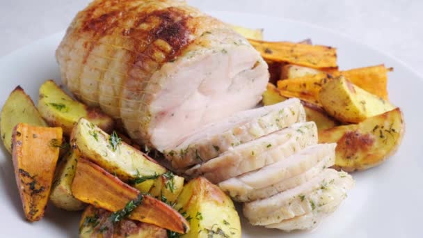 鶏の胸肉のロールは、お祝いのテーブルの上にジャガイモとサツマイモのガーニッシュを添えて. — ストック動画