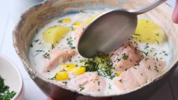 Sopa de pescado noruega con trucha, patatas y maíz, fondo gris. — Vídeo de stock
