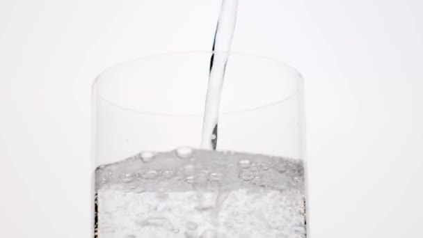 Tiszta víz öntött üveg fehér háttér. — Stock videók