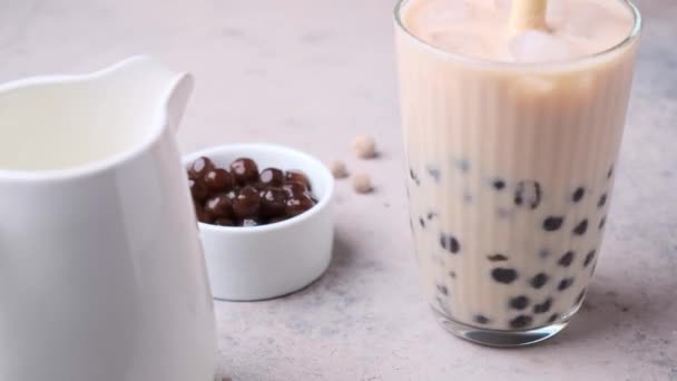 Tejbuborékos tea tápiókagyöngyökkel üvegben. — Stock videók
