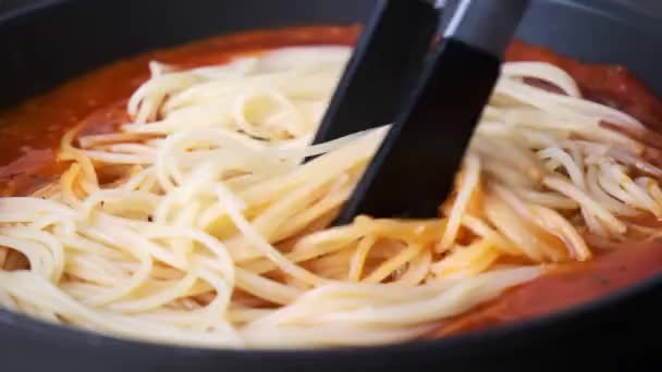 Paste de spaghete gătite în sos de roșii în tigaie. Conceptul bucătăriei italiene. — Videoclip de stoc