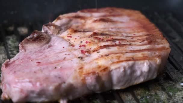 Cottura bistecca di maiale su padella nera. — Video Stock