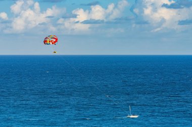 Parasailing towed behind a boat in the Caribbean sea, tropical Ocean, Vacation Concept, Cancun, Mexico.