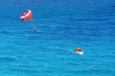 Parasailing towed behind a boat in the Caribbean sea, tropical Ocean, Vacation Concept, Cancun, Mexico.