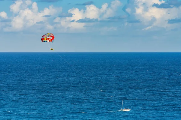 Parasailing towed behind a boat in the Caribbean sea, tropical Ocean, Vacation Concept, Cancun, Mexico.