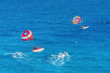 Parasailing towed behind a boat in the Caribbean sea, tropical Ocean, Vacation Concept, Cancun, Mexico.
