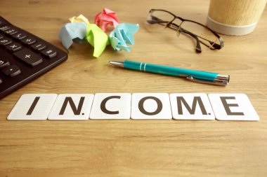Kalem, hesap makinesi ve gözlüklü kelime geliri, finansal konsept