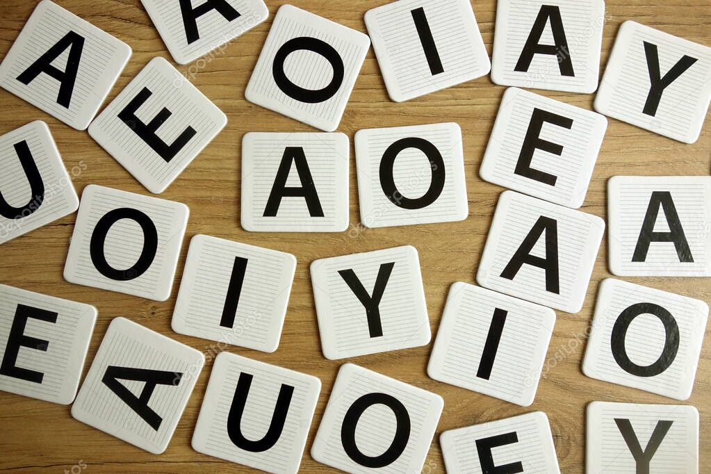 Vowel letters lying on desk, education concept
