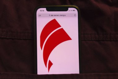 KONSKIE, POLAND - 18 Şubat 2022: Xiamen Xiangyu şirketinin logosu kot pantolon cebinde saklı cep telefonunda sergilendi