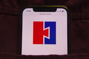 KONSKIE, POLAND - 22 Şubat 2022: Huafa Endüstriyel Sanayi Şirketi logosu kot pantolon cebinde saklı cep telefonunda sergilendi