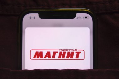 KONSKIE, POLAND - 27 Şubat 2022: PJSC Magnit logosu kot pantolon cebinde saklı cep telefonunda sergilendi