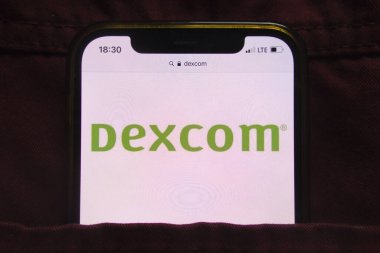 KONSKIE, POLAND - 27 Şubat 2022: DexCom Inc logosu kot pantolon cebine gizlenmiş cep telefonunda sergilendi