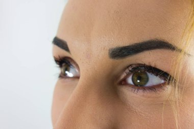 Kaşları doğal makyajlı güzel bir genç kadın. Güzel kahverengi gözler. Yakın görünüm, moda konsepti