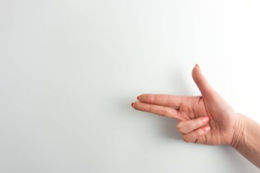 İki parmağıyla ateş eden bir kadının eli. Beyaz arkaplan, tasarım için kopyalama alanı