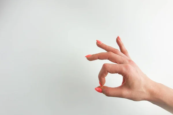 Ręka Kobiety Pastelowymi Pomarańczowymi Paznokciami Robi Gest Białe Tło Kopiuj — Zdjęcie stockowe