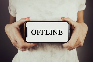 Bir kadın telefonu çevrimdışı tutuyor. İnternet bağlantısı, yayın kavramı