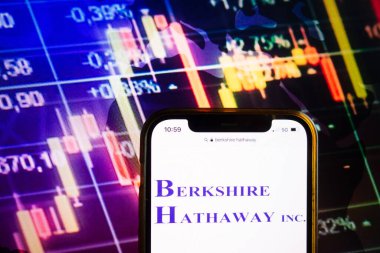 KONSKIE, POLAND - August 07, 2022: Smartphone displaying logo of Berkshire Hathaway Inc American multinational conglomerate holding company on stock exchange diagram background