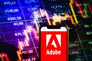 KONSKIE, POLAND - August 07, 2022: Smartphone displaying logo of Adobe Inc on stock exchange diagram background