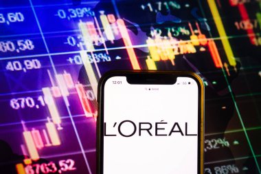 KONSKIE, POLAND - August 07, 2022: Smartphone displaying logo of LOreal SA company on stock exchange diagram background