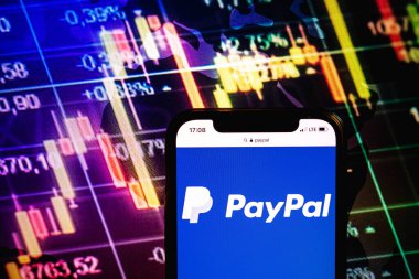 KONSKIE, POLAND - August 09, 2022: Smartphone displaying logo of PayPal company on stock exchange diagram background