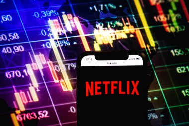 KONSKIE, POLAND - August 09, 2022: Smartphone displaying logo of Netflix company on stock exchange diagram background