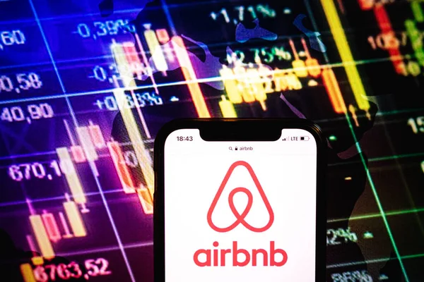 KONSKIE, POLAND - August 09, 2022: Smartphone displaying logo of Airbnb company on stock exchange diagram background
