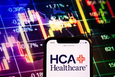 KONSKIE, POLAND - August 10, 2022: Smartphone displaying logo of HCA Healthcare company on stock exchange diagram background