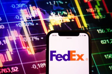 KONSKIE, POLAND - August 10, 2022: Smartphone displaying logo of FedEx company on stock exchange diagram background