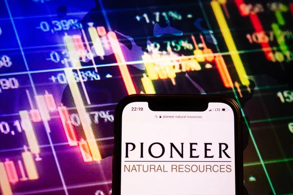 KONSKIE, POLAND - August 10, 2022: Smartphone displaying logo of Pioneer Natural Resources company on stock exchange diagram background