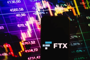 KONSKIE, POLAND - August 10, 2022: Smartphone displaying logo of FTX cryptocurrency exchange on stock exchange diagram background