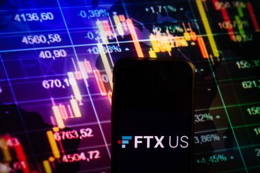 KONSKIE, POLAND - August 10, 2022: Smartphone displaying logo of FTX US cryptocurrency exchange on stock exchange diagram background