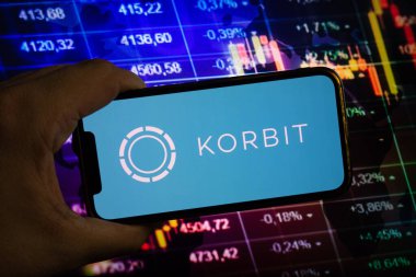 KONSKIE, POLAND - August 10, 2022: Smartphone displaying logo of Korbit cryptocurrency exchange on stock exchange diagram background