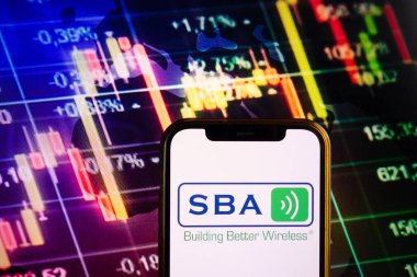 KONSKIE, POLAND - 10 Eylül 2022: Borsa şeması üzerinde SBA İletişim şirketinin logosunu gösteren akıllı telefon