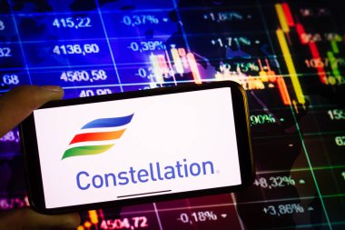 KONSKIE, POLAND - 10 Eylül 2022: Takımyıldız Enerjisi şirketinin logosunu borsa şeması üzerinde gösteren akıllı telefon