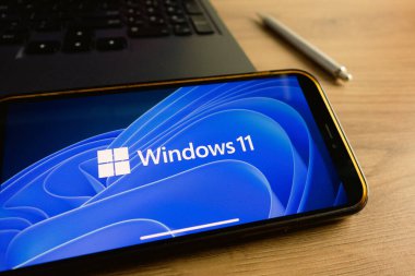 KONSKIE, POLAND - 17 Eylül 2022: Windows 11 logosu ofisteki akıllı telefon ekranında sergilendi. Windows 11, Microsoft 'un Windows NT işletim sisteminin en son sürümü