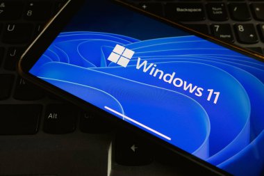 KONSKIE, POLAND - 17 Eylül 2022: Windows 11 logosu ofisteki akıllı telefon ekranında sergilendi. Windows 11, Microsoft 'un Windows NT işletim sisteminin en son sürümü